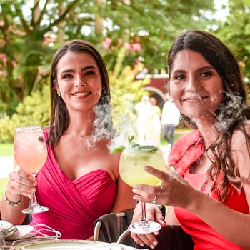 Dos mujeres con bebidas de mixología con humo por Tahiti Mixology en una hacienda en Mérida, Yucatán, México